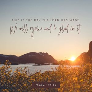 A glorious sunrise over a lake surrounded by hills, with the words "This is the day that the Lord has made - We will rejoice and be glad in it. Psalm 118:24".